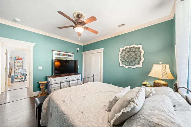a bedroom with a bed and a flat tv screen on the dresser