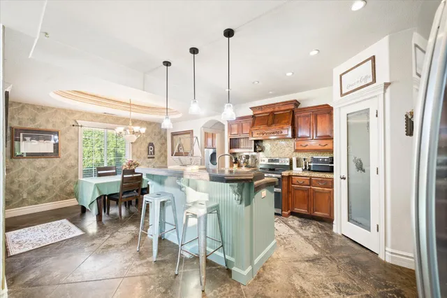 a kitchen with stainless steel appliances granite countertop sink stove and refrigerator