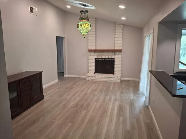 an empty room with wooden floor and fireplace