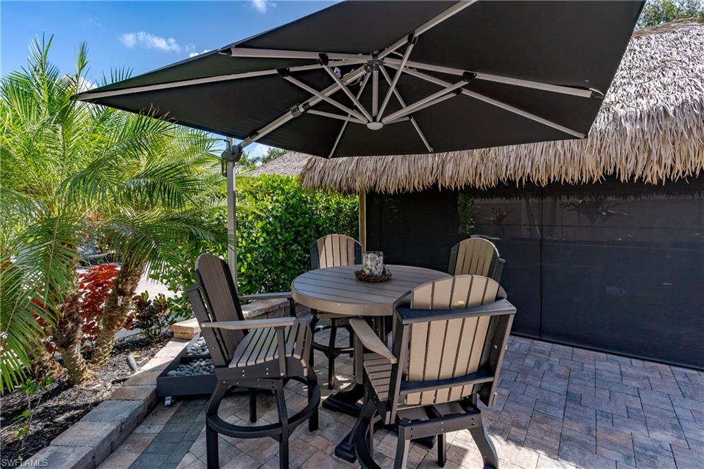 13571 Snook Circle Naples, FL 34114 - Photo 14 of 47 a patio with a patio table and chairs