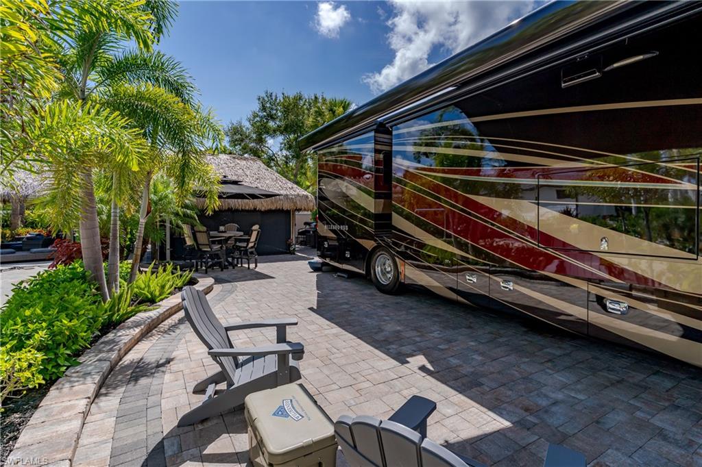 13571 Snook Circle Naples, FL 34114 - Photo 22 of 47 a backyard of a house with barbeque oven table and chairs