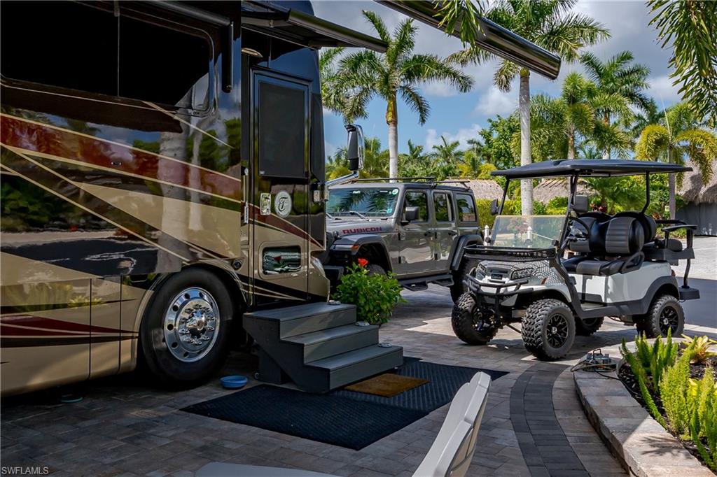 13571 Snook Circle Naples, FL 34114 - Photo 37 of 47 a view of a car garage with a car parked under an umbrella