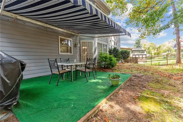 a view of a house with backyard and sitting area
