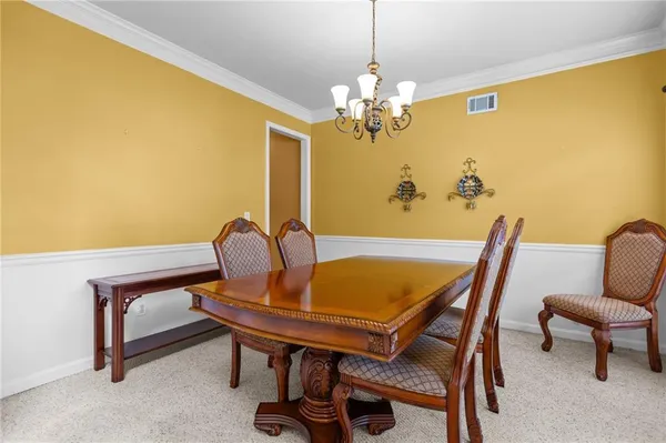 a view of a dining room with furniture and chandelier