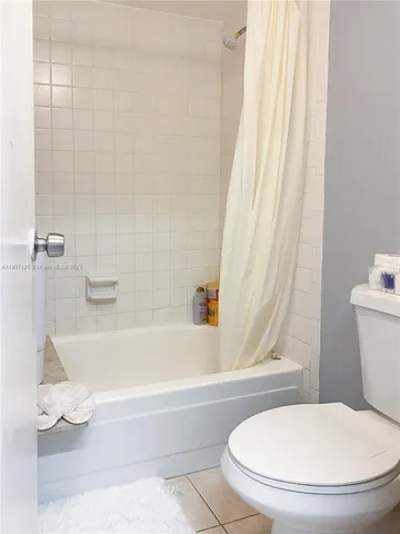 a white toilet sitting next to a bath tub