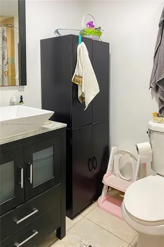 a bathroom with a toilet a sink and mirror