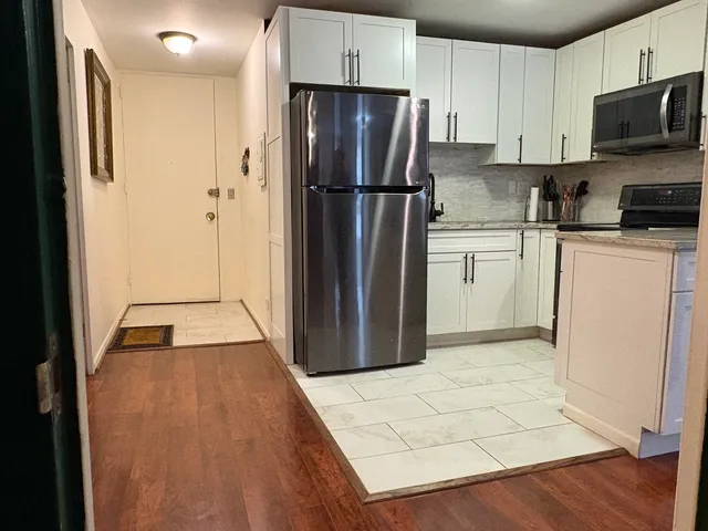 a kitchen with refrigerator cabinets and wooden floor