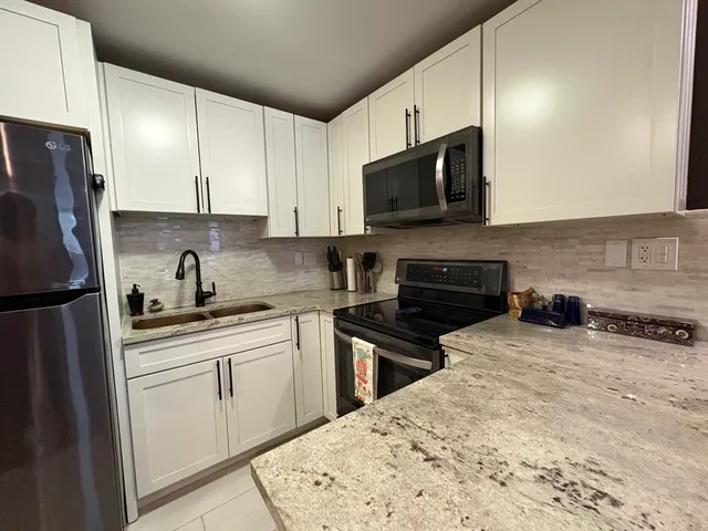 a kitchen with stainless steel appliances a refrigerator and a stove top oven