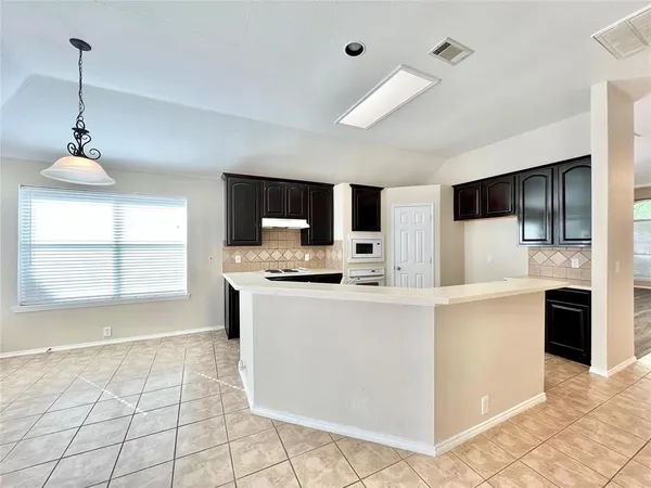 a living room with stainless steel appliances kitchen island granite countertop a sink and a stove top oven