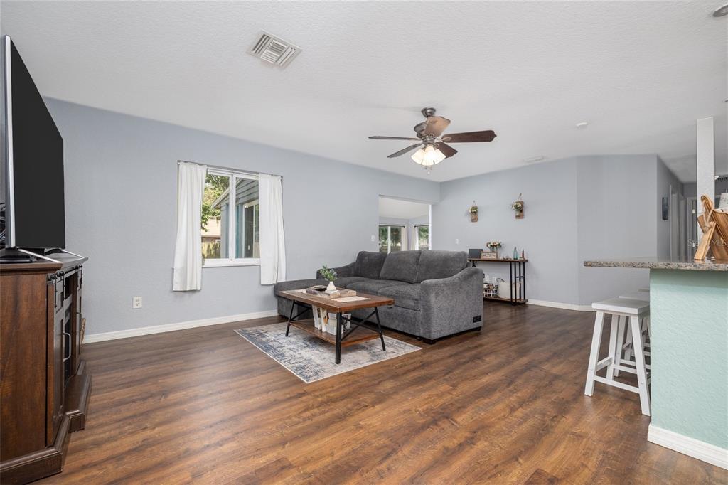 1709 Umbrella Tree Drive Edgewater, FL 32132 - Photo 13 of 37 a living room with furniture a ceiling fan and a window