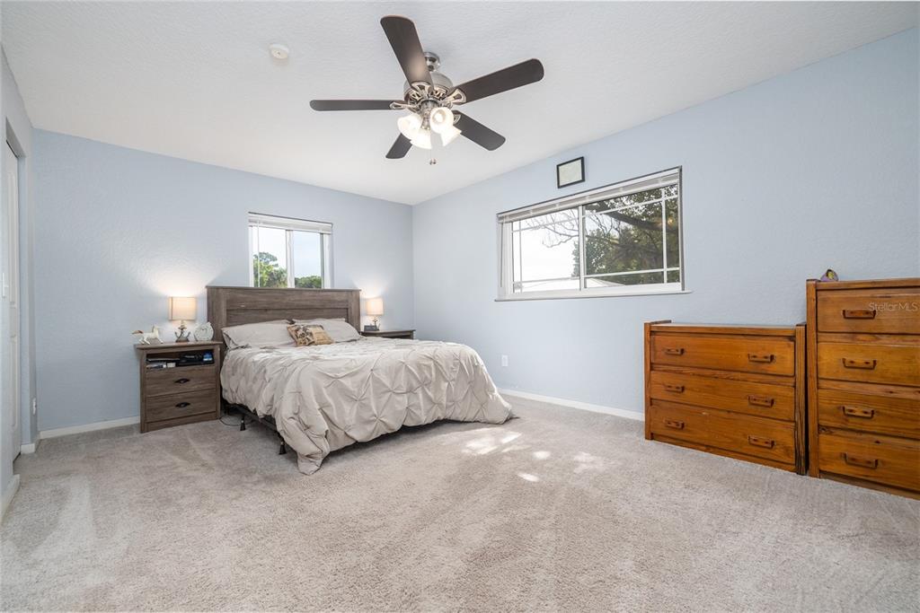 1709 Umbrella Tree Drive Edgewater, FL 32132 - Photo 15 of 37 a bedroom with a bed and ceiling fan