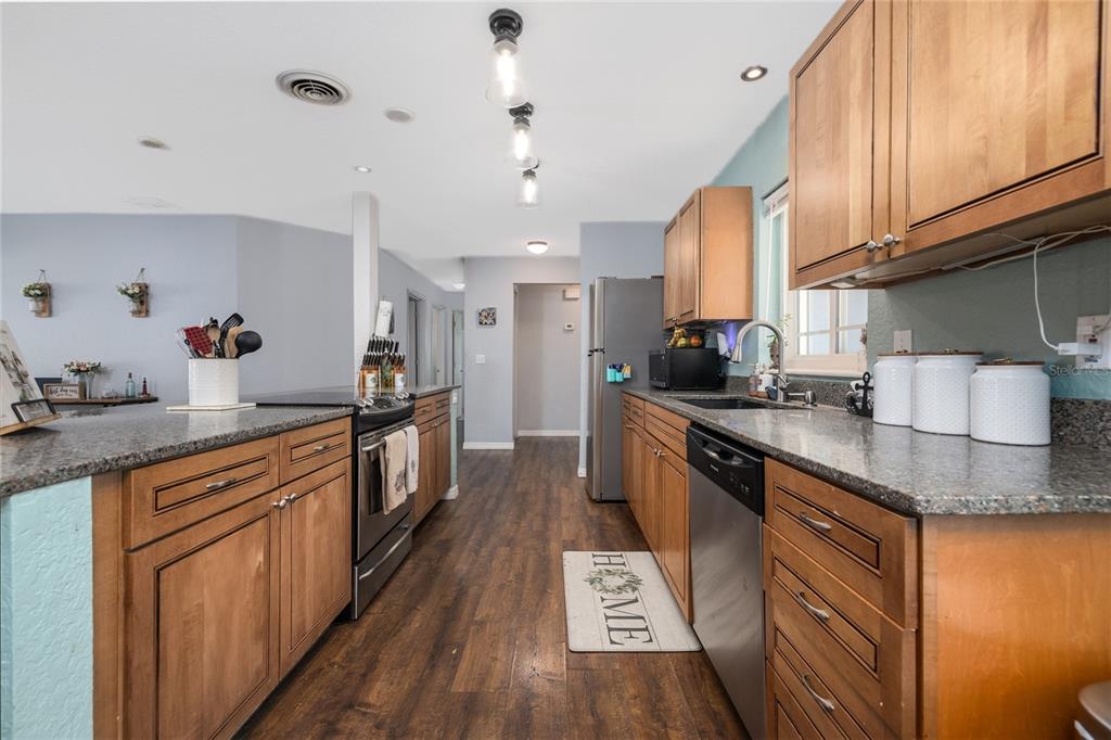 1709 Umbrella Tree Drive Edgewater, FL 32132 - Photo 6 of 37 a kitchen with stainless steel appliances granite countertop a sink a stove and a refrigerator