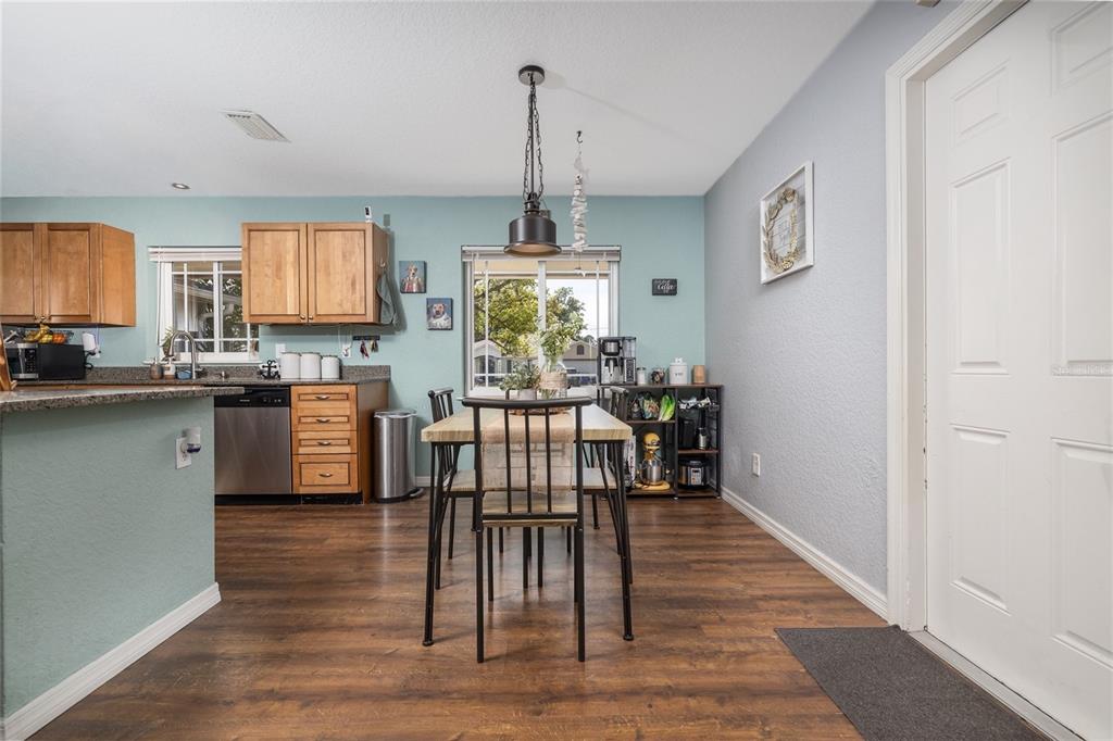 1709 Umbrella Tree Drive Edgewater, FL 32132 - Photo 8 of 37 a kitchen with stainless steel appliances granite countertop a stove top oven a sink dishwasher and a dining table with wooden floor