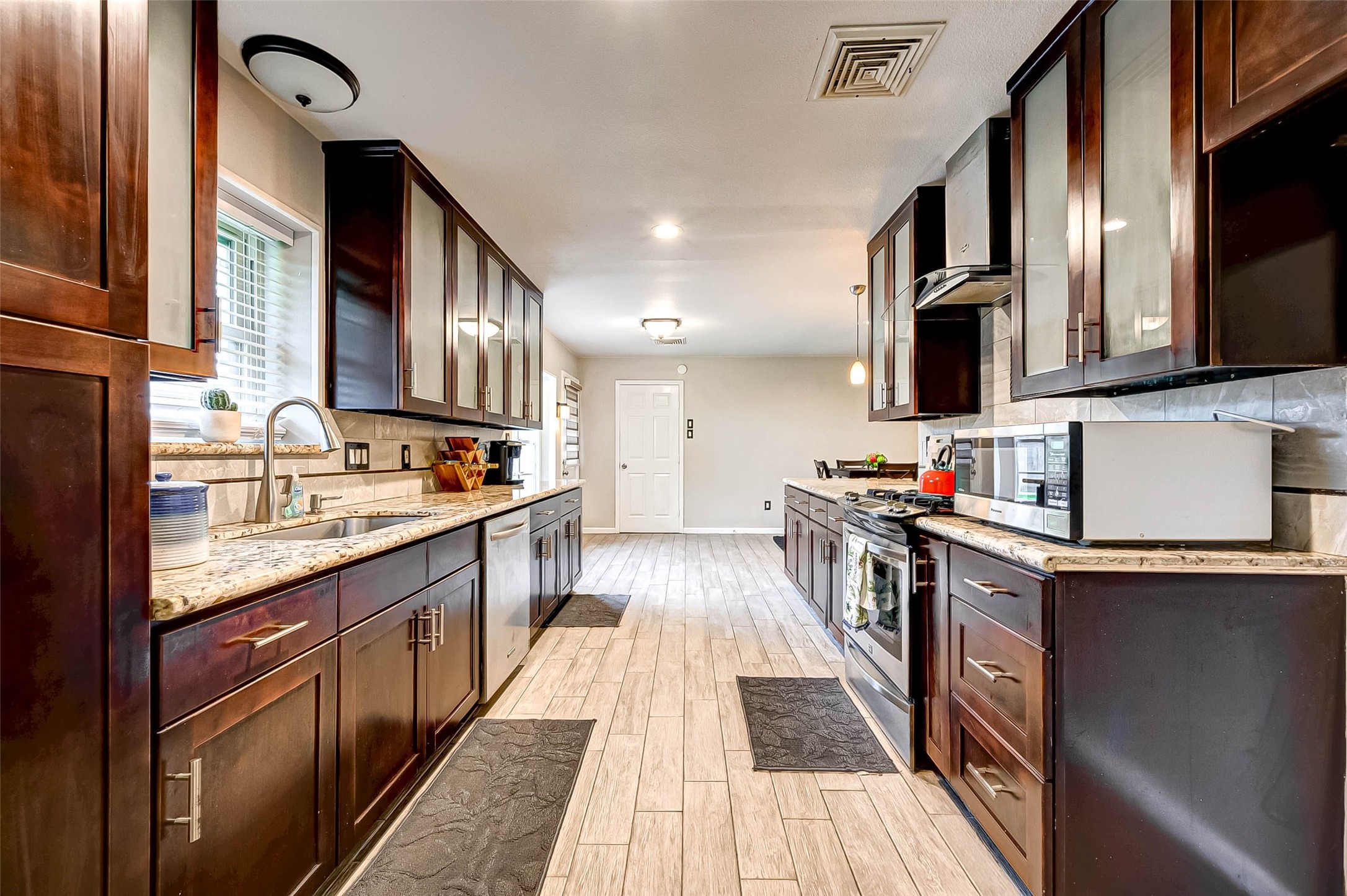 6119 Reamer Street Houston, TX 77074 - Photo 11 of 33 a kitchen with stainless steel appliances granite countertop a stove and a sink