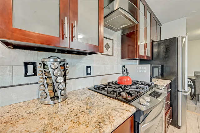 a kitchen with stainless steel appliances granite countertop a stove and a refrigerator