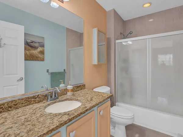 a bathroom with a granite countertop sink toilet and shower