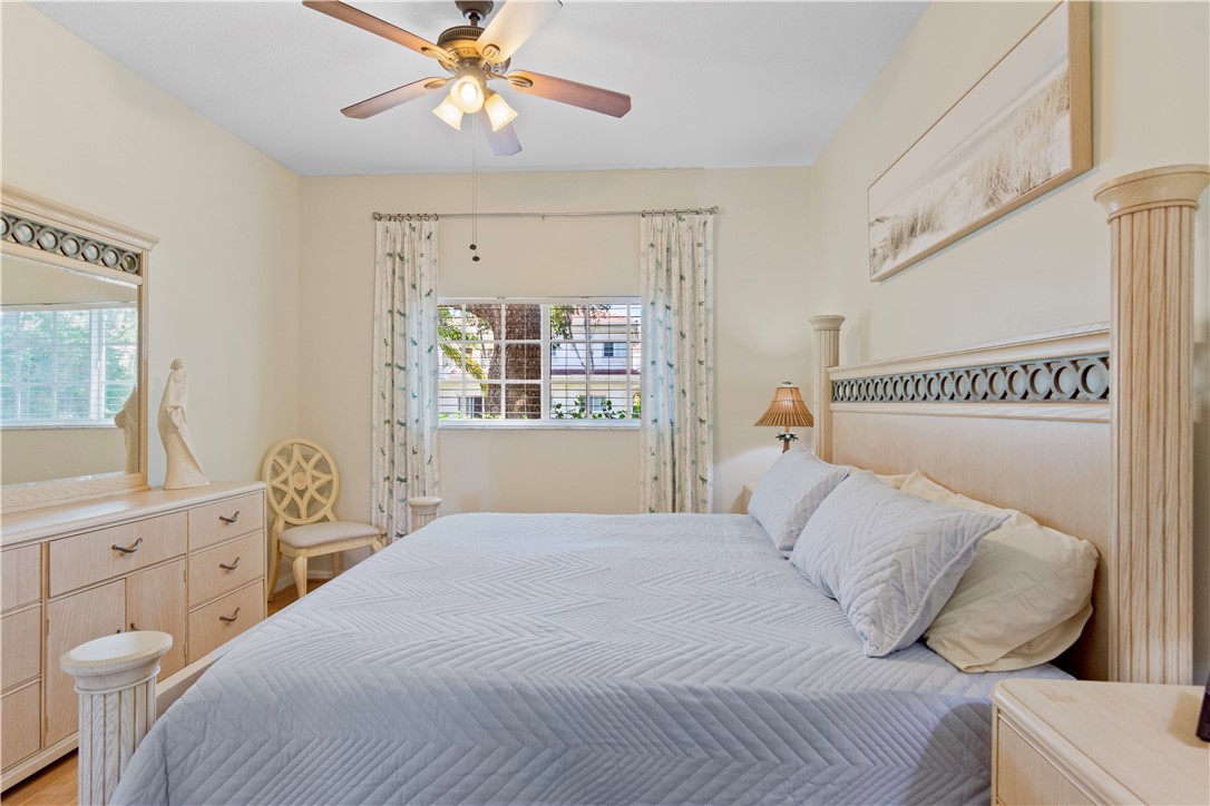 528 7th Square Southwest, Unit 102 Vero Beach, FL 32962 - Photo 13 of 28 a bedroom with a bed and a chandelier