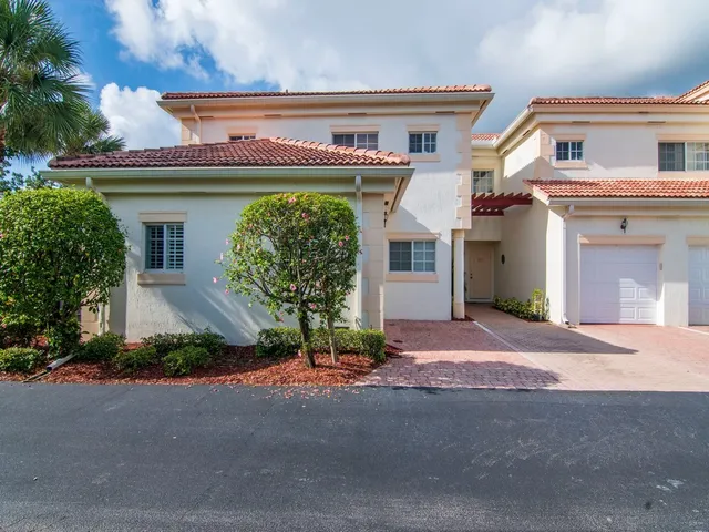 a front view of a house with a garage and a yard