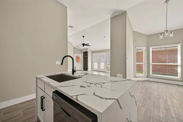 a view of a kitchen with a sink and chandelier