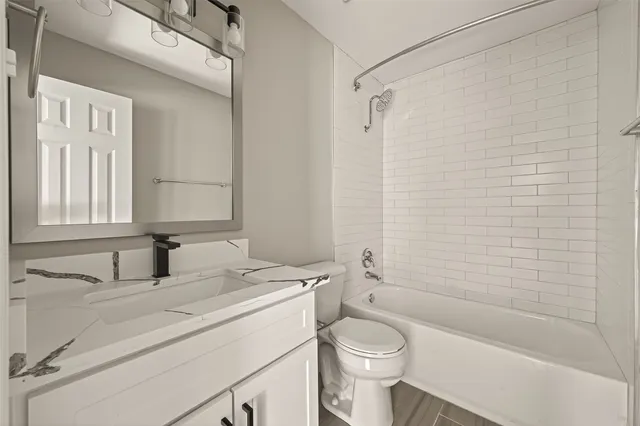 a bathroom with a sink toilet vanity and shower