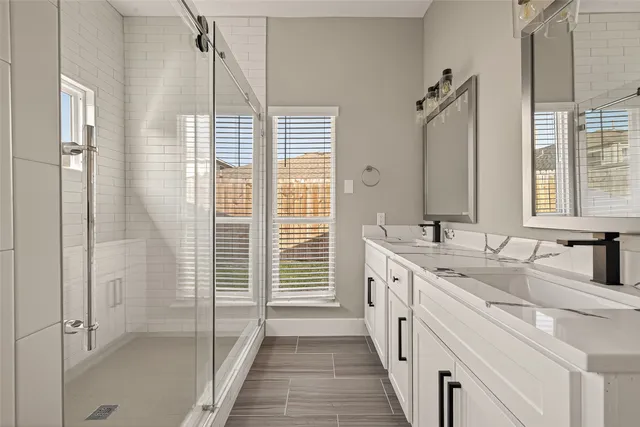 a large white kitchen with a granite countertop sink