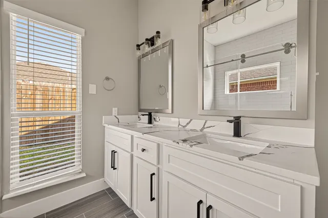 a bathroom with a double vanity sink and mirror
