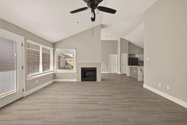 a view of an empty room with a fireplace and a window