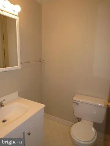 a white toilet sitting next to a white sink and vanity