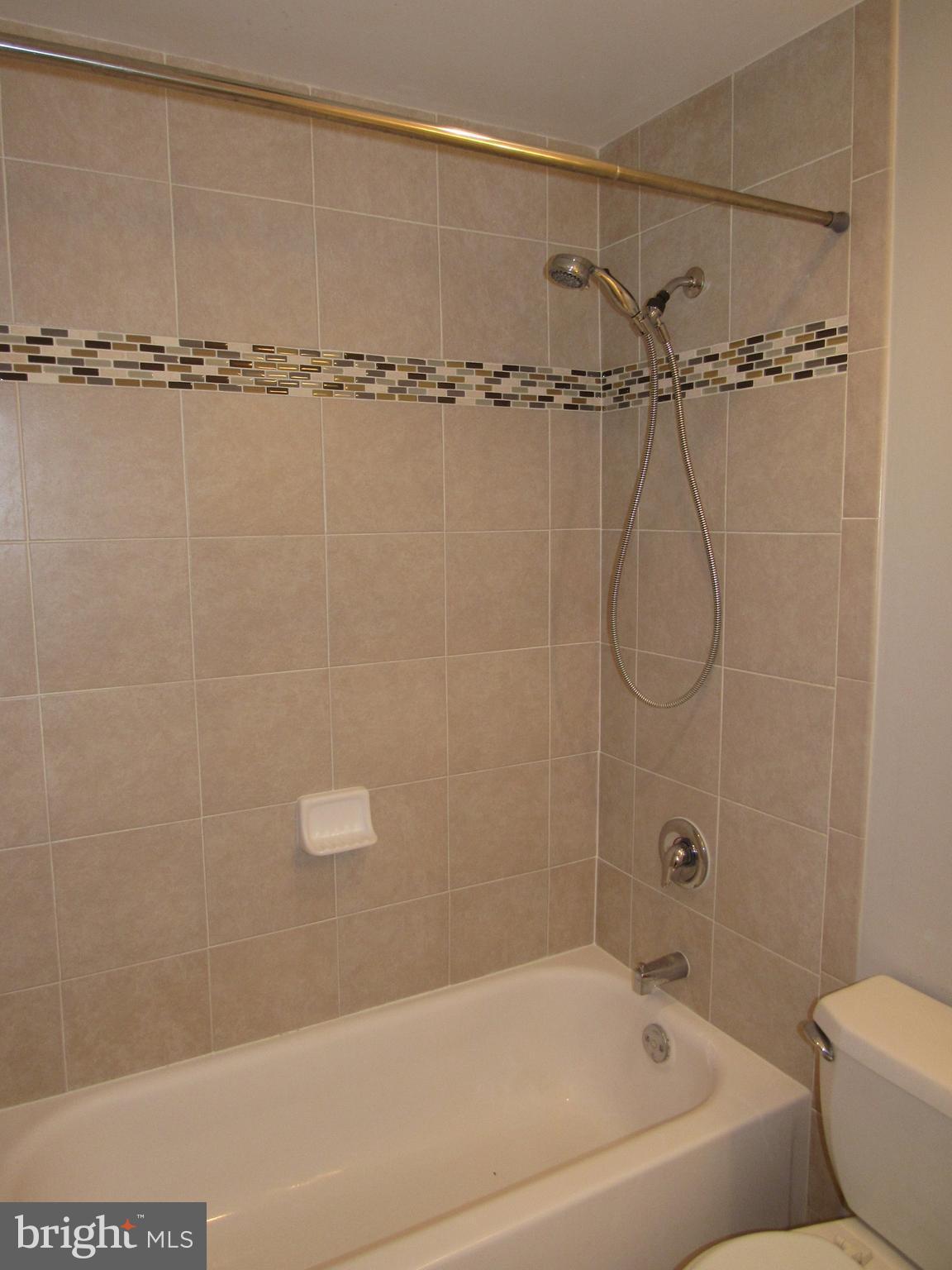 11200 Chestnut Grove Square, Unit 303 Reston, VA 20190 - Photo 20 of 30 a bathroom with a bathtub and a shower