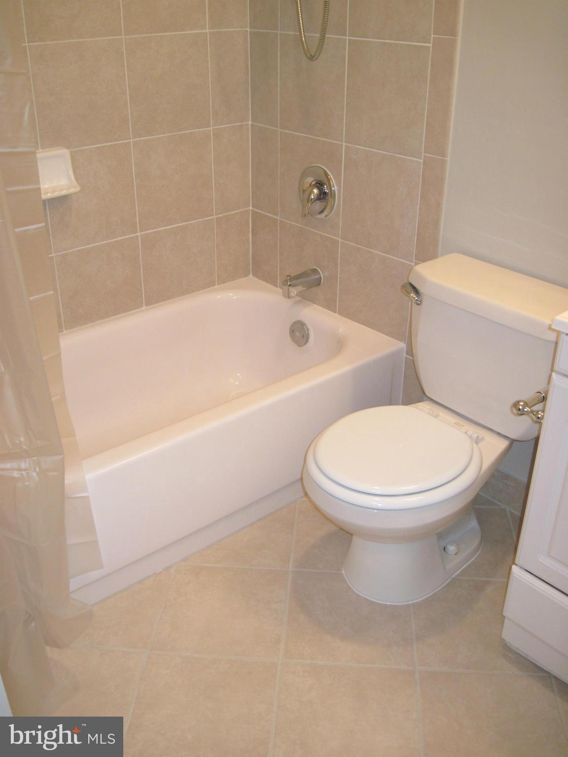 11200 Chestnut Grove Square, Unit 303 Reston, VA 20190 - Photo 21 of 30 a white toilet sitting next to a bath tub