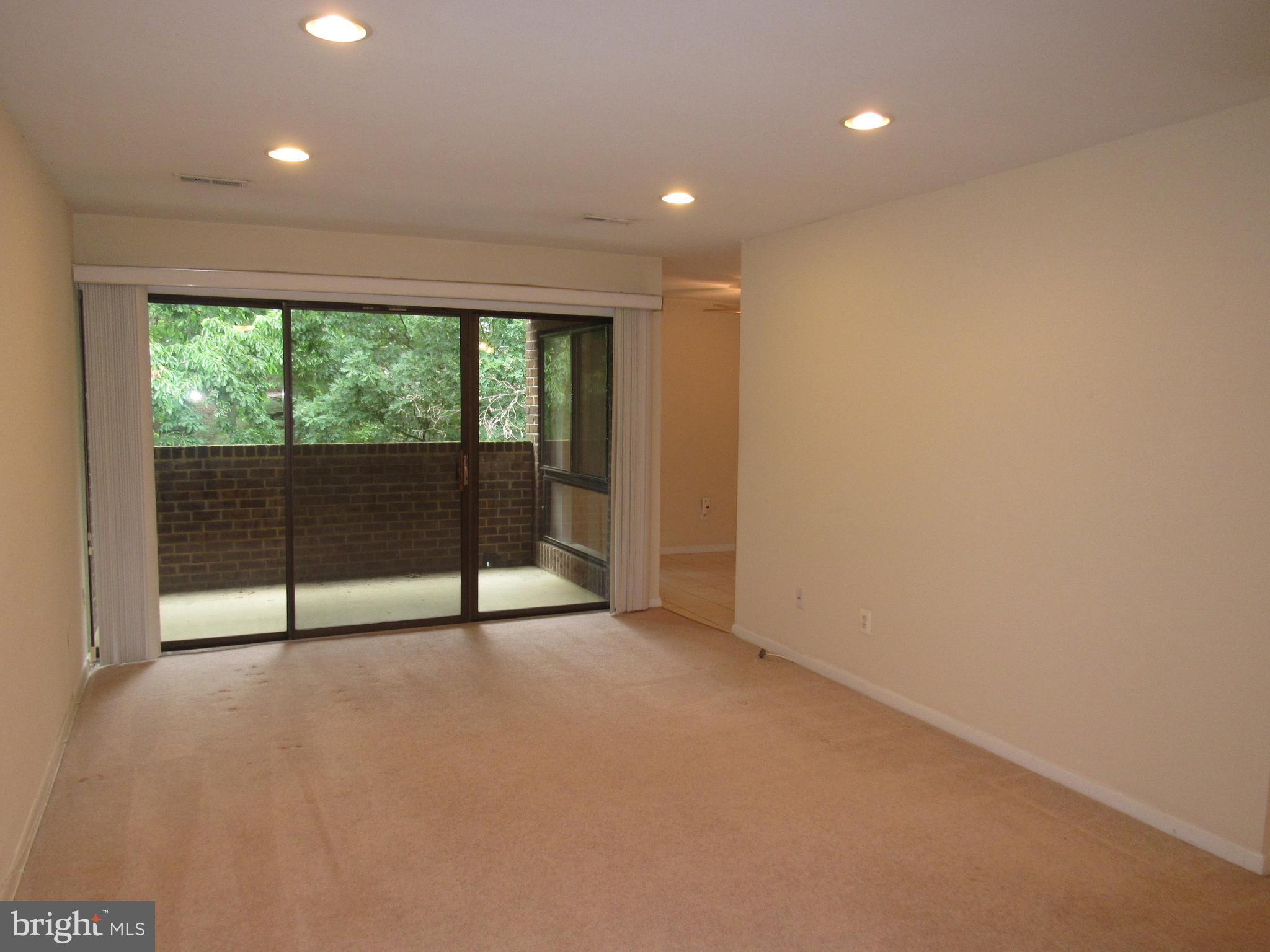 11200 Chestnut Grove Square, Unit 303 Reston, VA 20190 - Photo 4 of 30 a view of an empty room with wooden floor and a window