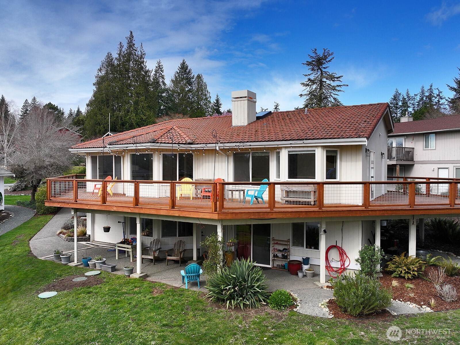 a view of a white house with a big yard and potted plants