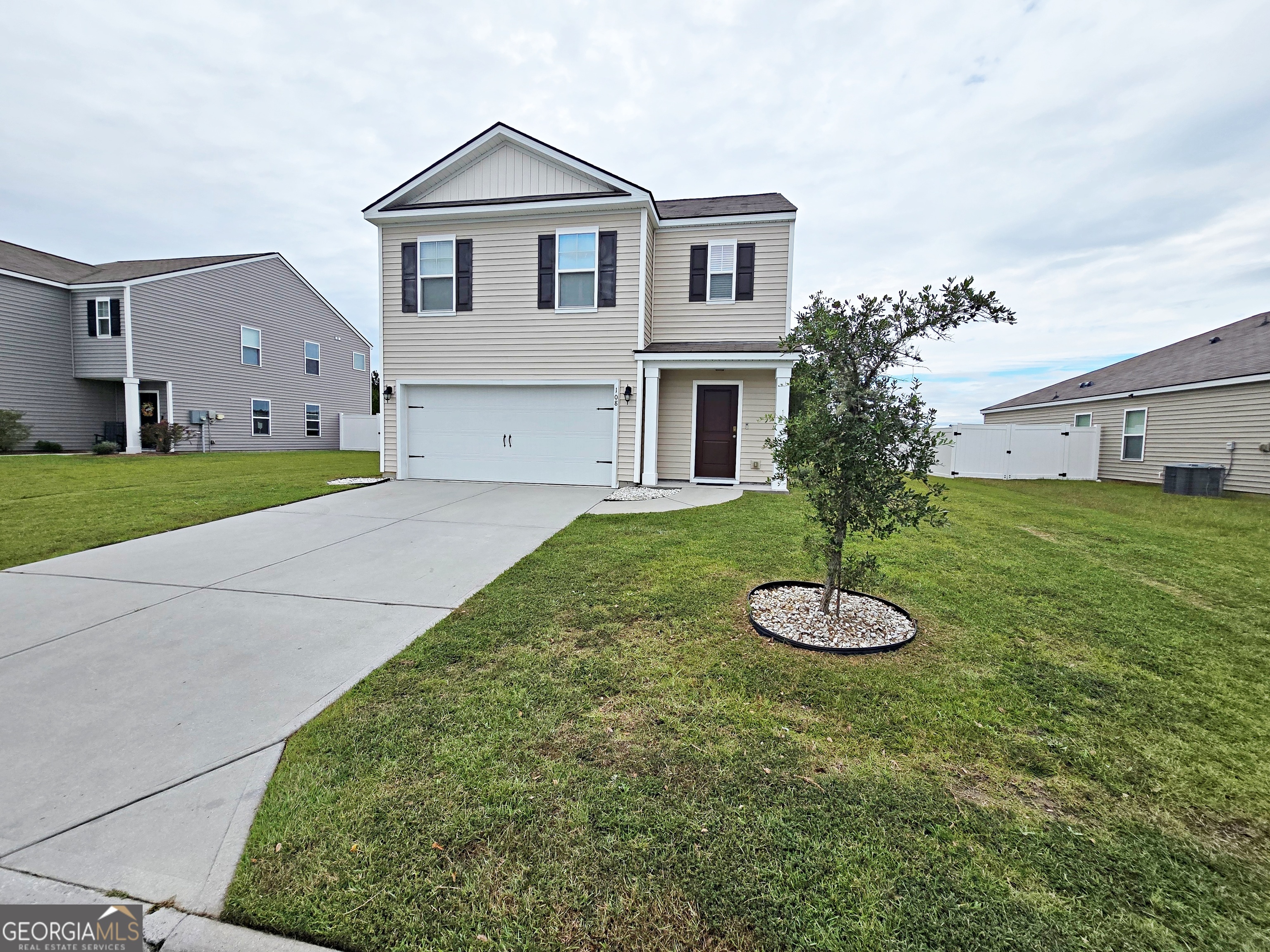 a front view of a house with a yard and garage