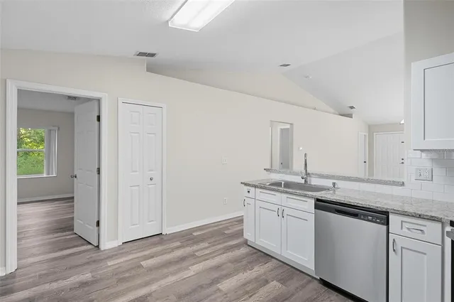 a kitchen with a sink cabinets and wooden floor