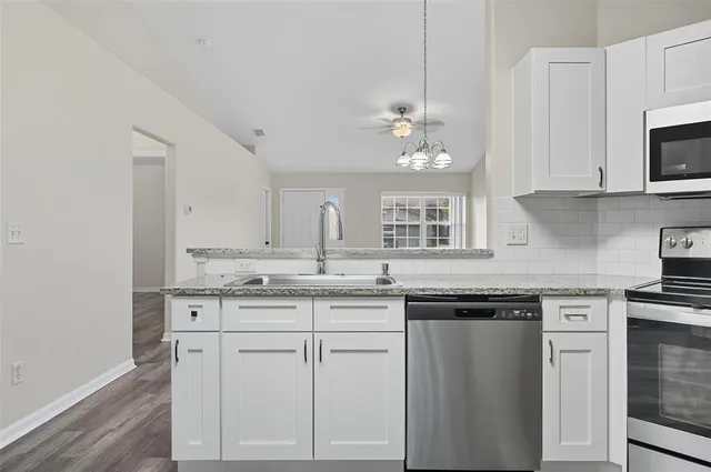 a kitchen with white cabinets and appliances