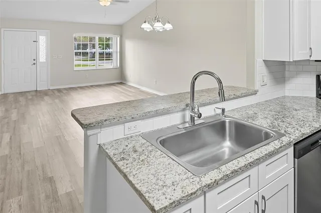 a kitchen with granite countertop a sink and a stove
