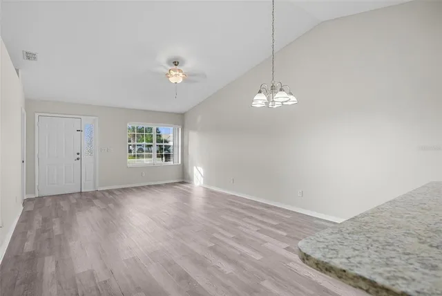 a view of a room with wooden floor and chandelier