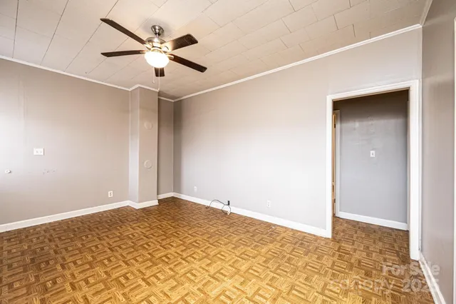 a view of a big room with wooden floor and a ceiling fan