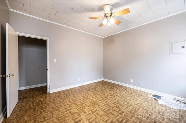 an empty room with a window and a ceiling fan
