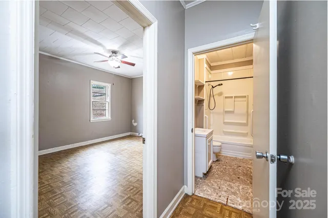 a view of a hallway view with wooden floor and a bathroom