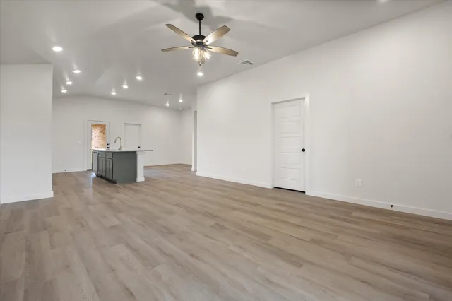 an empty room with wooden floor and window