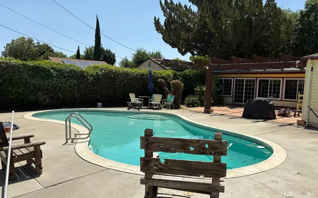a view of a swimming pool with a patio and plants
