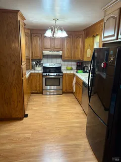 a kitchen with stainless steel appliances a stove refrigerator sink and cabinets