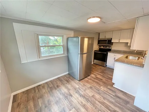 a kitchen with stainless steel appliances granite countertop a refrigerator sink and stove