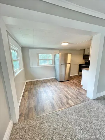 an empty room with wooden floor and window