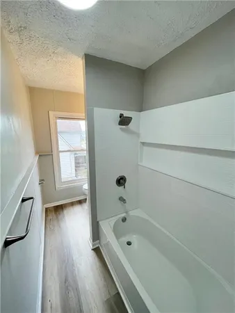 a bathroom with a tub a sink and a window