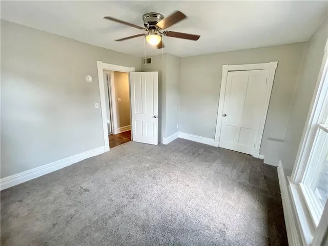a view of a big room with chandelier fan and windows