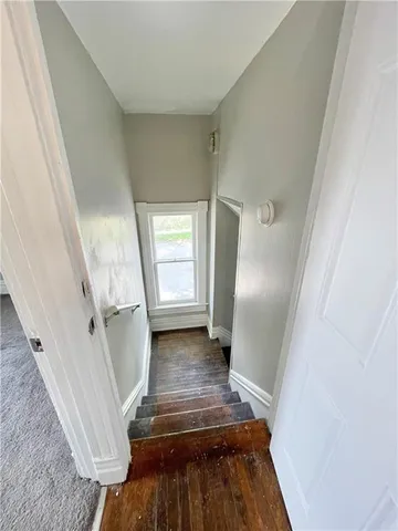 a view of a livingroom with wooden floor and stairs
