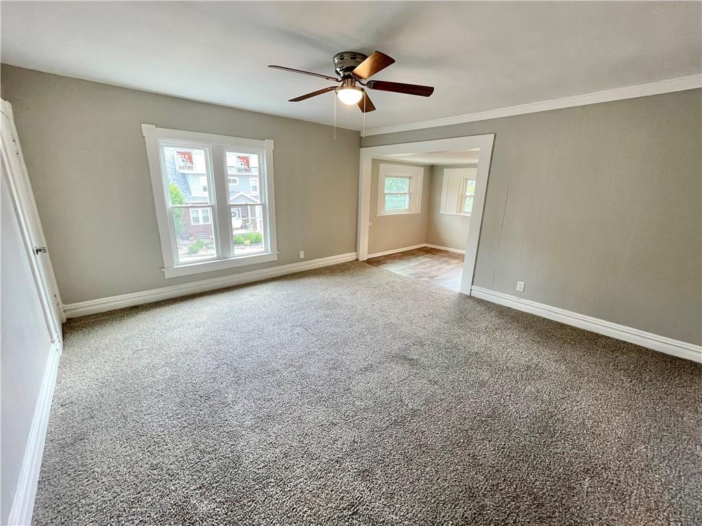 811 Carlisle Street, Unit 2 New Castle, PA 16101 - Photo 5 of 23 an empty room with windows and ceiling fan