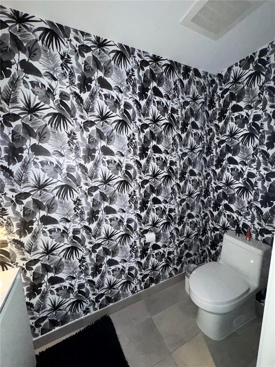 788 Northeast 23rd Street, Unit 1202 Miami, FL 33137 - Photo 26 of 64 a bathroom with a toilet and a shower curtain